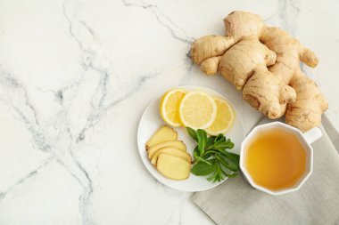 Hafif arkaplanda zencefilli, nane ve limon dilimli çay.