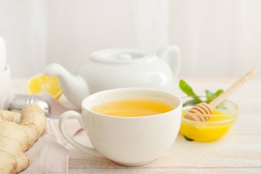 Çaydanlık ve çay. Hafif ahşap arka planda zencefil.