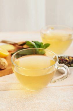 Zencefilli çay bardakları ve hafif ahşap arka planda nane.