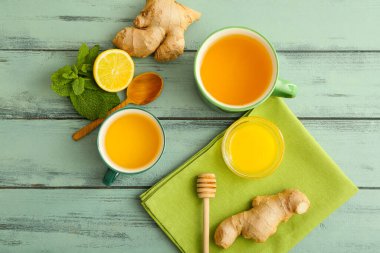 Zencefilli çay, bal ve limon renkli ahşap arka planda