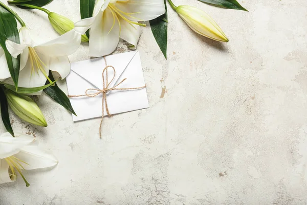 Güzel zambak çiçekleri ve açık arkaplanda bir mektup