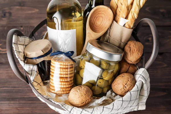 Gift basket with products on wooden table, closeup