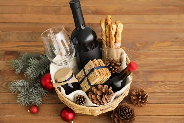 木桌上装有产品和圣诞装饰的礼篮 — 图库照片