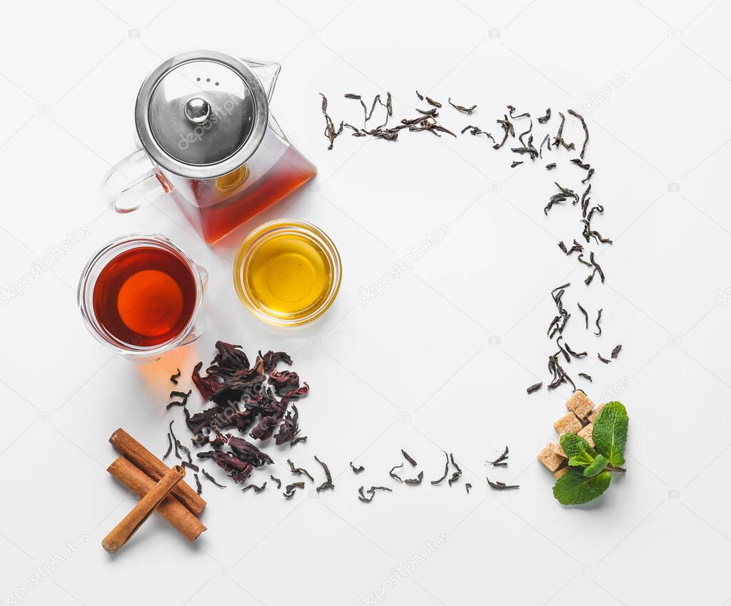Frame made of teapot and glass with tasty tea, honey and mint on white background