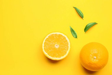 Arkaplanda yeşil yapraklı taze portakallar