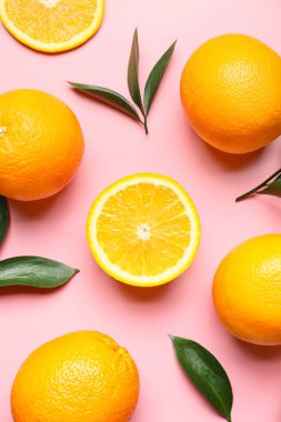 Arkaplanda yeşil yapraklı taze portakallar