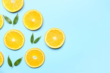 Arkaplanda yeşil yapraklı taze portakal dilimleri