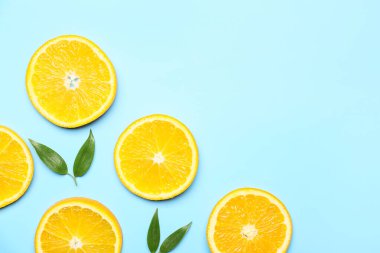 Arkaplanda yeşil yapraklı taze portakal dilimleri