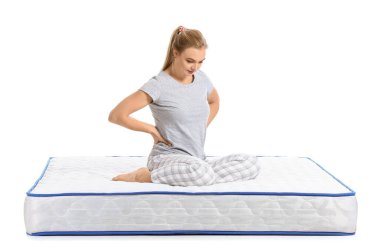 Beyaz arka planda, yatakta acı çeken olgun bir kadın.