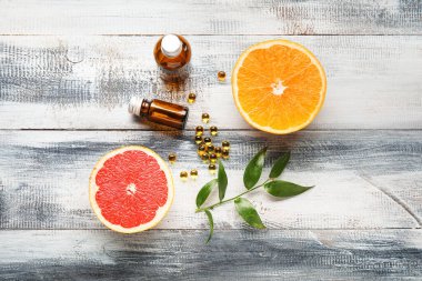 C vitamini hapları ve ahşap arka planda narenciye meyveleri içeren kompozisyon