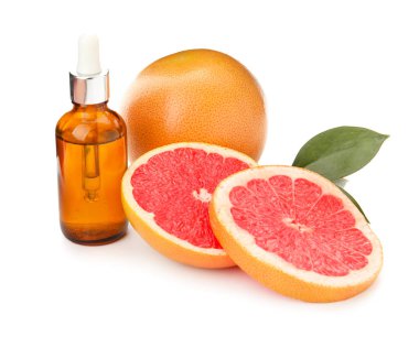 C vitamini ve beyaz arka planda greyfurt içeren bir şişe gerekli yağ.