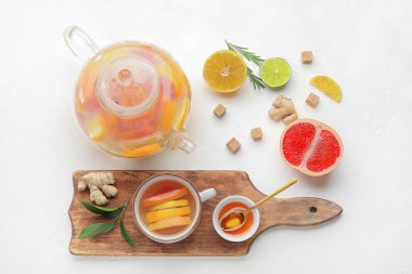 Lezzetli zencefilli çay ve beyaz arka planda malzemelerle kompozisyon