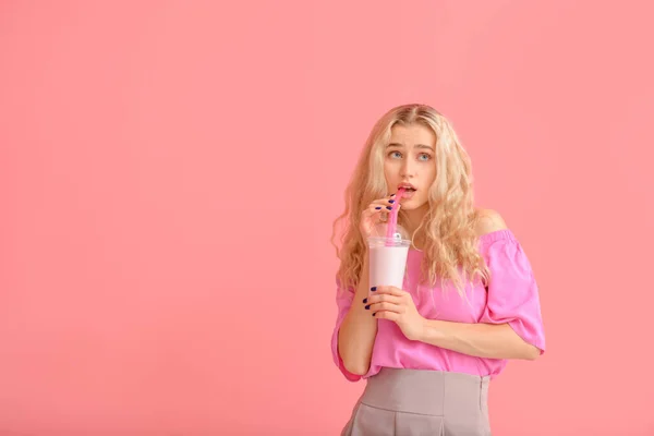 Fashionable young woman with cocktail on color background