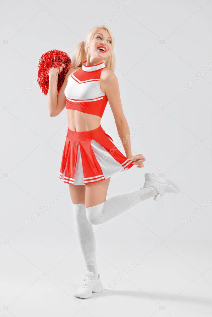 Beautiful cheerleader on light background