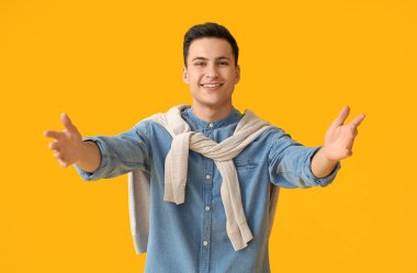 Genç adam sarıImak için kollarını araladı.