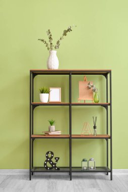 Renk duvarına yakın dekorlu modern kitap rafı.