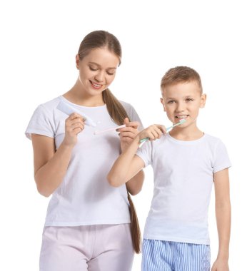 Anne ve küçük oğlu beyaz arka planda diş fırçalıyorlar.