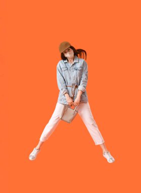 Renkli arka planda maske takan şık bir genç kadın.