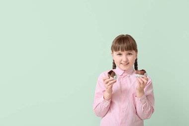 Çikolatalı, arka planda Paskalya yumurtaları olan tatlı küçük bir kız.