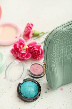 Dekoratif kozmetik ürünleri olan şık bir çanta, yakın plan.