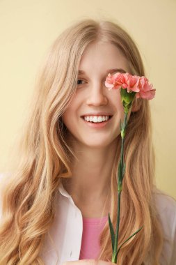 Arka planda karanfil çiçeği olan genç bir kadın.