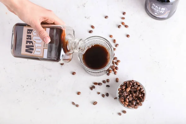 Woman Pouring Tasty Cold Brew Bottle Glass Light Background — Stock Photo, Image