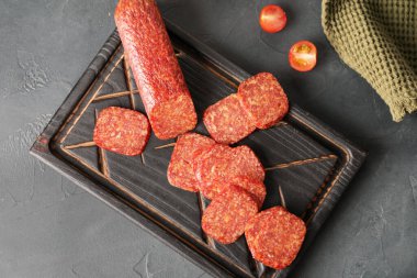 Koyu arkaplanda lezzetli salam olan tahta