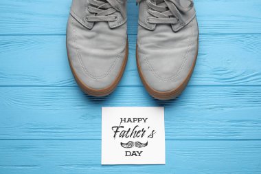 Babalar günü için renkli tahta arka planda tebrik kartı olan erkek ayakkabıları.