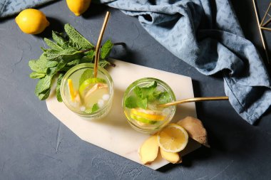 Koyu arkaplanda zencefilli limonata bardakları olan tahta.