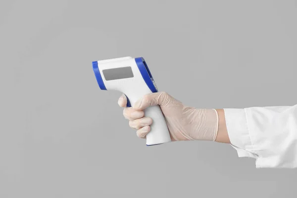 Hand Van Arts Met Infrarood Thermometer Grijze Achtergrond — Stockfoto