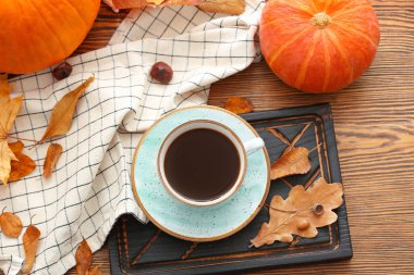 Güzel sonbahar kompozisyonu, bir fincan kahve ve ahşap arka planda balkabağı.