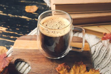 Güzel sonbahar kompozisyonu, bir fincan kahve ve koyu ahşap zemin üzerine kitaplar, yakın plan.