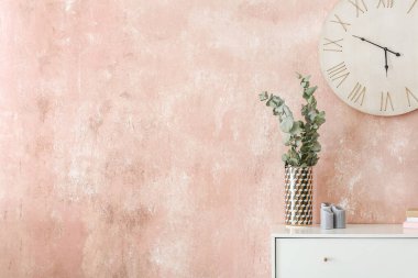 Çiçek desenli çekmeceler ve renkli duvarların yanında mumlar.