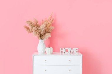 Renk duvarının yanında çiçek desenli çekmeceler.