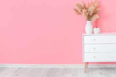 Renk duvarının yanında çiçek desenli çekmeceler.