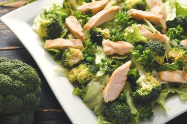 Taze sebzeli lezzetli salata ve koyu arkaplanda tavuk.