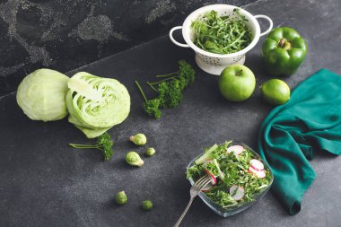 Koyu arkaplanda taze sebzeli bir kase lezzetli salata