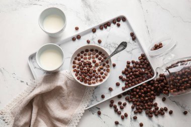 Çikolatalı mısır topları ve arka planda süt olan bir kase.