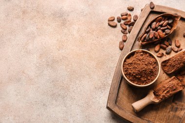 Kakao tozu ve açık arkaplanda fasulye ile kase ve kepçe