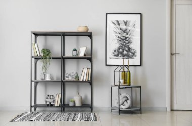 Kitaplı modern raf ünitesi ve beyaz duvarın yanındaki masa.