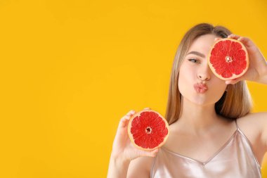 Arkaplanda greyfurt olan güzel bir genç kadın.