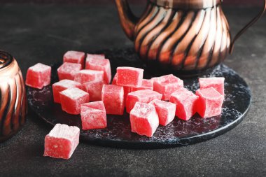 Koyu arkaplanda Türk lokumlu tabak ve çaydanlık