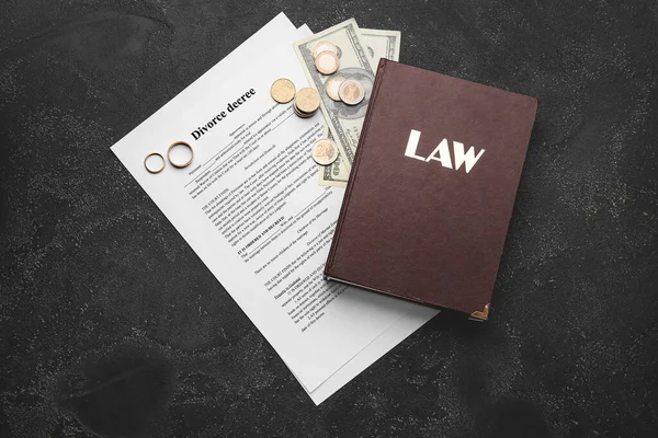 Divorce decree with law book and money on dark background