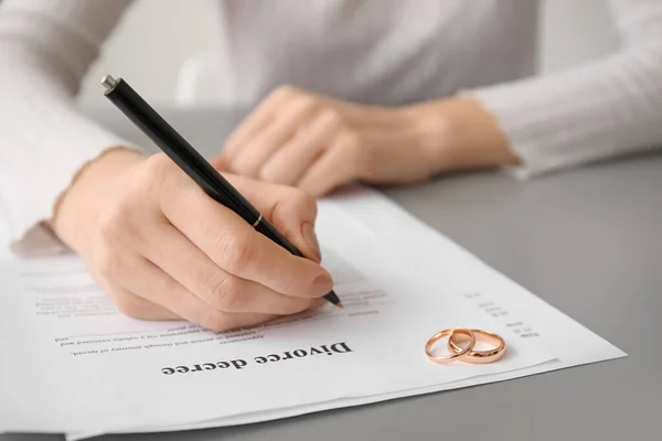 テーブルで離婚の布告にサインする女 — ストック写真