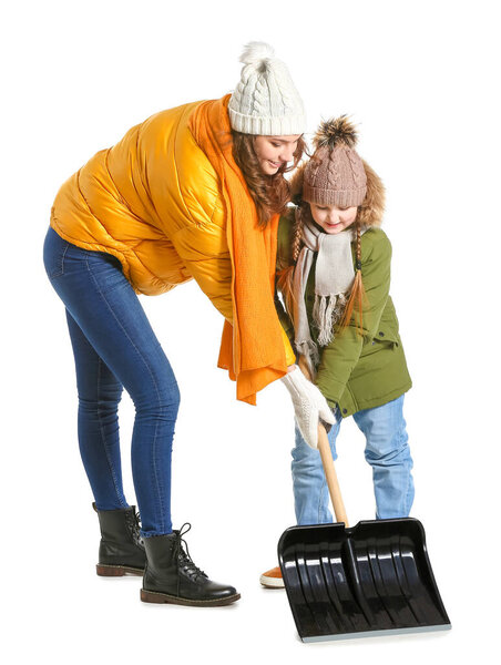 Woman and her little daughter with shovel for removing snow on white background