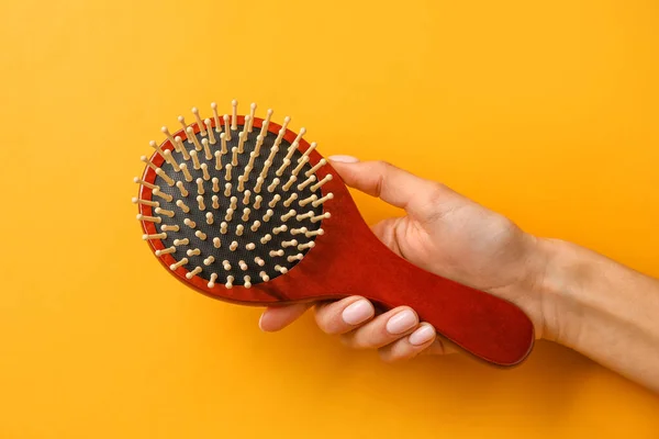 Mano Femminile Con Spazzola Capelli Legno Sfondo Colore — Foto Stock