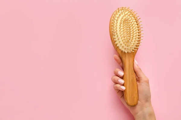 Mão Feminina Com Escova Cabelo Madeira Fundo Cor — Fotografia de Stock