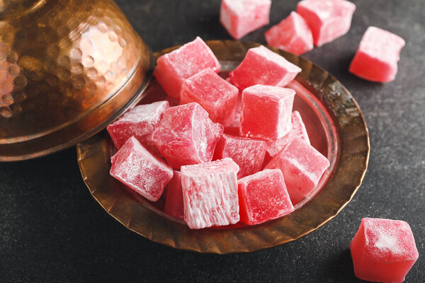 Plate with Turkish delight on dark background, closeup