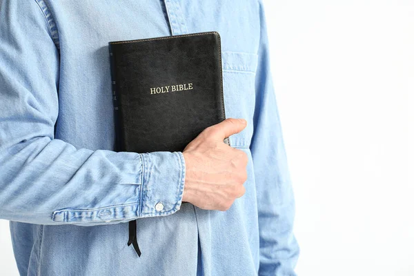 Man with Bible on white background, closeup