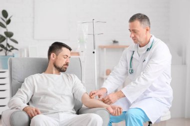 Doktor ve adam klinikte kemoterapi görüyorlar. Prostat kanseri farkındalığı